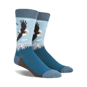 A pair of blue crew socks with a graphic design of a bald eagle soaring over a mountain landscape.