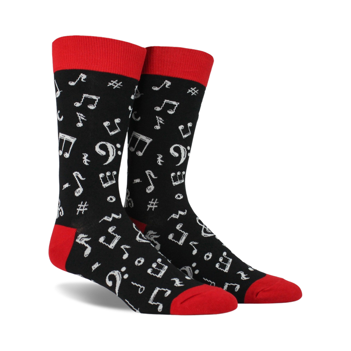 Pair of black crew socks with a red cuff.  White musical notes and symbols are printed all over.