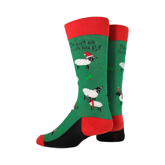 A pair of green and red socks with a pattern of cartoon sheep wearing Santa hats. The socks have a red toe and heel, and a black cuff.