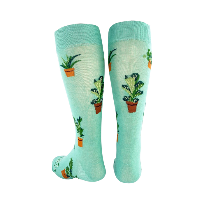 A pair of mint green knee-high socks with a pattern of potted plants.