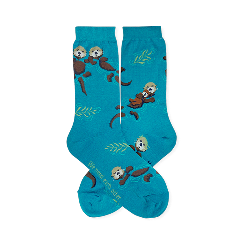 Teal crew socks featuring brown floating sea otters, green kelp, and text reading We need each otter near the toe.