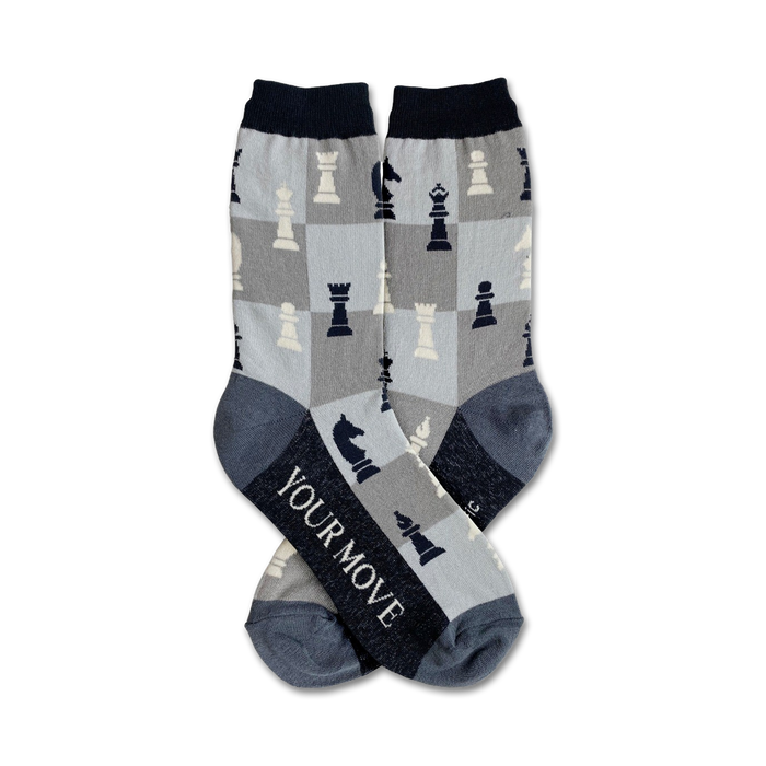 Pair of crew socks in gray and navy blue with a chessboard pattern and chess pieces. The socks say 'YOUR MOVE' on the heel. }}