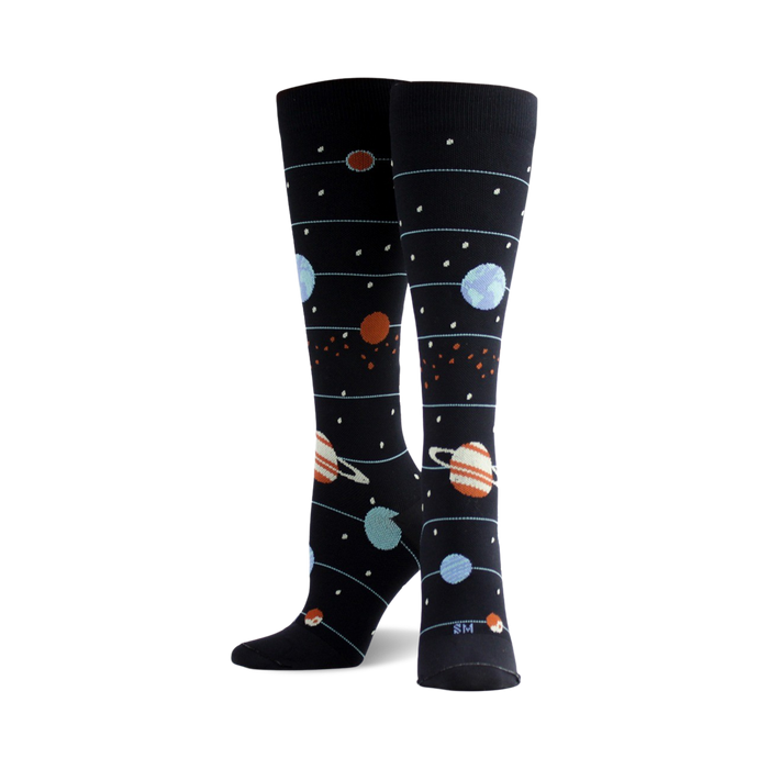 Pair of women's knee-high socks.  Navy blue background with planets (blue, orange, and ringed) and stars in a solar system design. }}