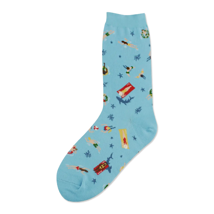 A light blue crew sock features swimmers, sunbathers, sharks, and starfish on a whimsical beach scene. }}