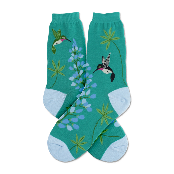 Crew socks in teal green, featuring colorful hummingbirds and lupine flowers. Light blue cuffs add a touch of contrast. }}