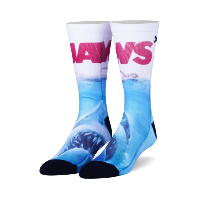 Pair of crew socks; white background with 'JAWS' in red, depicting a great white shark underwater in shades of blue. }}