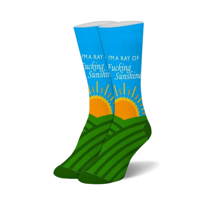 Pair of blue crew socks with green hills, an orange rising sun, and