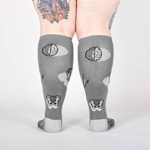 Back view of the anatomical socks on a model's legs.  Shows the full design of the socks, including brains and pelvis bones.