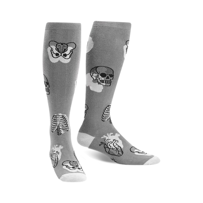 Pair of gray knee-high socks with a whimsical anatomical design. Features skulls, ribcages, and hearts in grayscale.