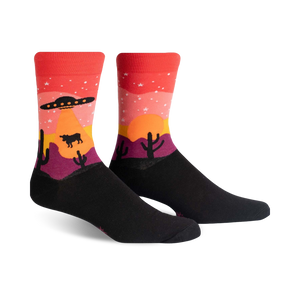 Crew socks in black, red, orange, and purple, featuring a desert sunset scene with a UFO, stars, cacti, and a cow.