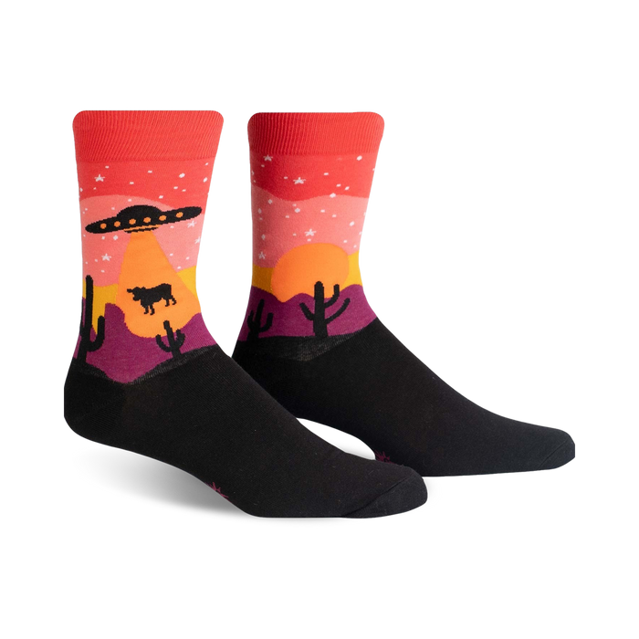 Crew socks in black, red, orange, and purple, featuring a desert sunset scene with a UFO, stars, cacti, and a cow.
