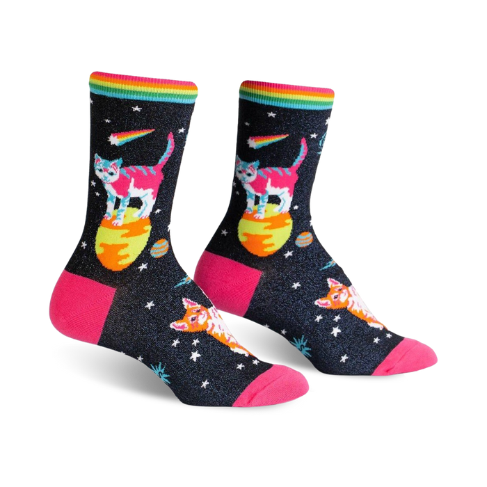 Pair of women's crew socks. Black background with colorful space cats, planets, and rainbow stripe. Pink heel and toe.