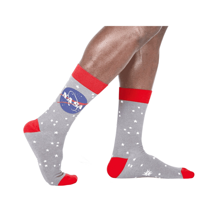 mens crew socks featuring a pattern of white stars and nasa logo logo on gray with red cuff and heel. available in size medium.   }}