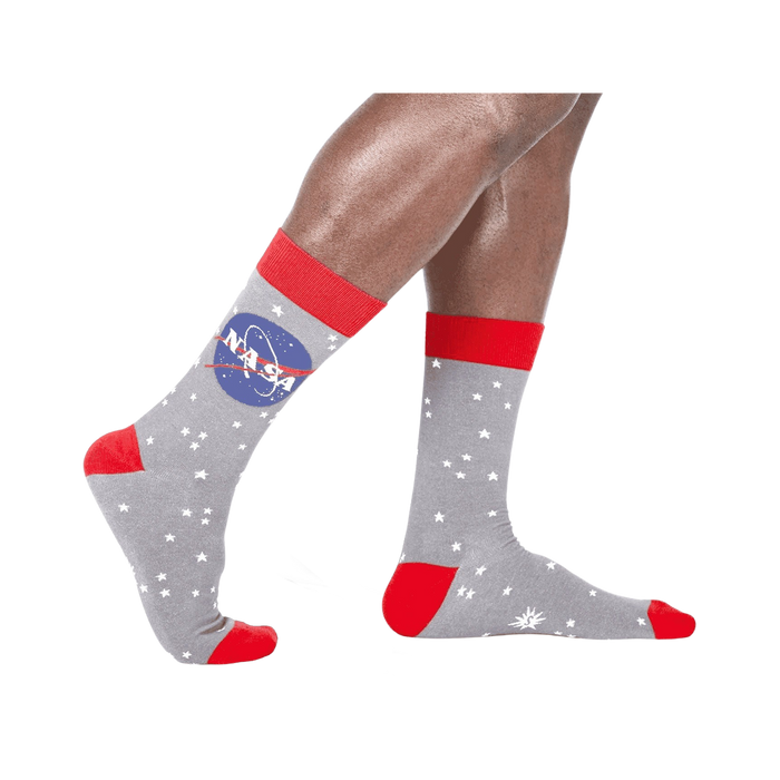 A pair of gray crew socks with the NASA logo and white stars. Red accents on the cuffs and toes. Glow in the dark feature. }}