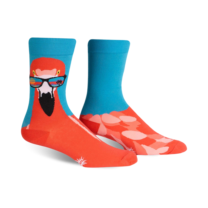 bright orange crew socks with pink flamingos in sunglasses against a light blue cloudy background.     }}