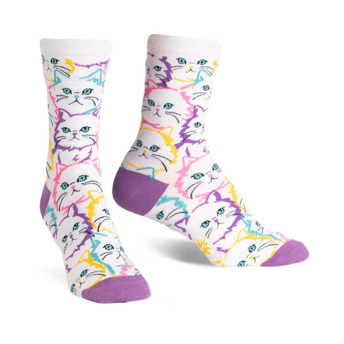 Pair of crew socks with a white background and repeating pattern of pastel-colored cat faces in purple, pink, and yellow. }}