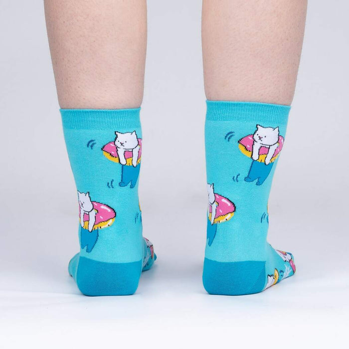 A pair of blue socks with a pattern of white cats wearing pink inner tubes.