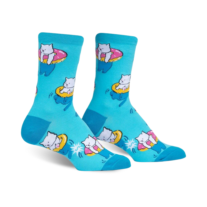Crew socks in teal featuring a pattern of white cats riding pink donut inner tubes.