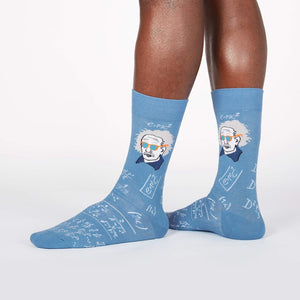 A pair of blue socks with a pattern of Albert Einstein's face and equations.