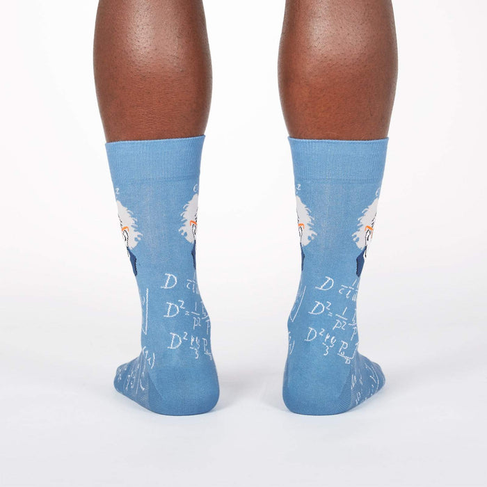 A pair of blue socks with a pattern of Albert Einstein's face and equations.