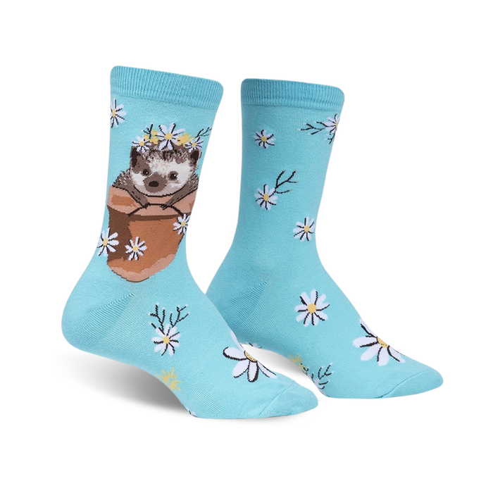 Pair of light blue crew socks featuring a cute hedgehog in a flower pot wearing a daisy crown, surrounded by smaller daisies.
