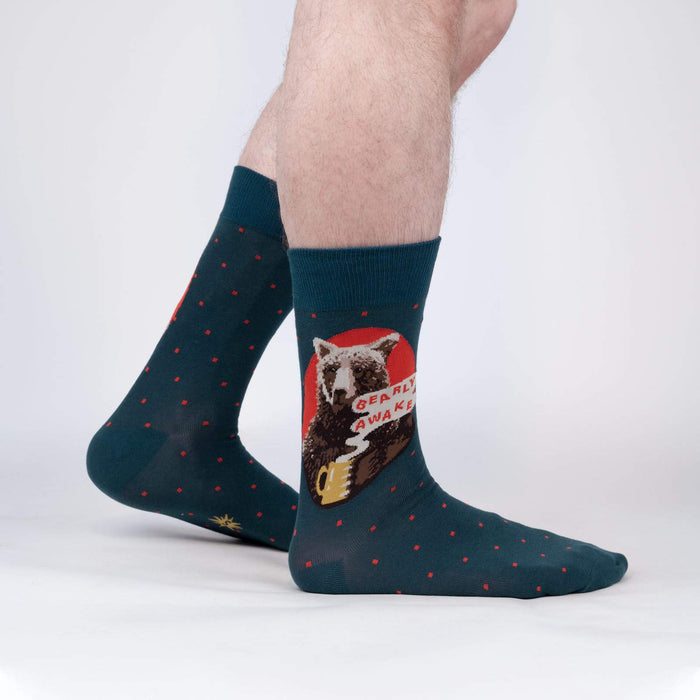 Lifestyle shot of a man modeling 'Bearly Awake' socks; showcasing how they look when worn.