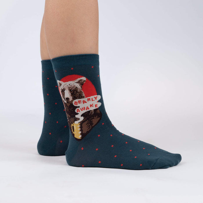 A pair of blue socks with a red panda drinking from a yellow mug design on each sock.