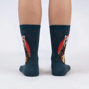 A pair of blue socks with a red panda drinking from a yellow mug design on each sock.