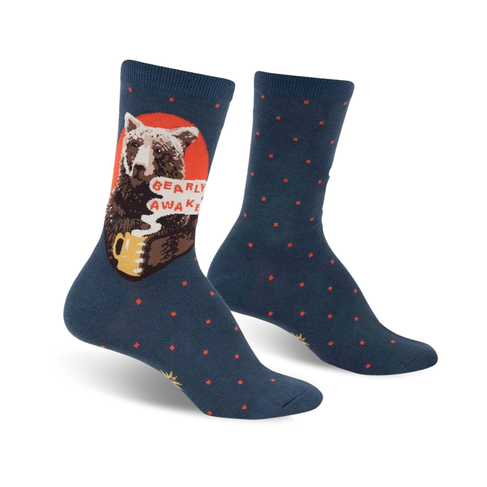 A pair of teal crew socks with a brown bear drinking coffee and the words 'Bearly Awake'.  Red accents and small red polka dots decorate the socks.