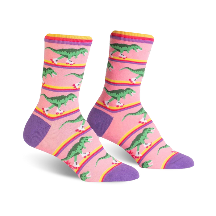 Crew socks in pink, purple, and yellow, featuring a pattern of green dinosaurs roller-skating.