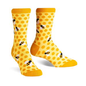 Pair of crew socks in yellow and black. The socks have a honeycomb pattern with little bees.