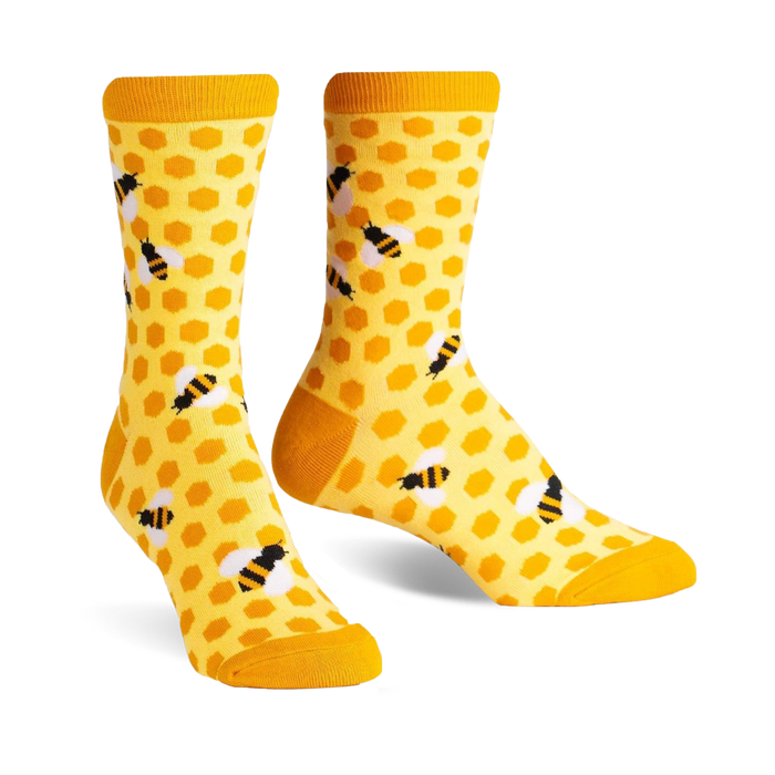 Pair of crew socks in yellow and black. The socks have a honeycomb pattern with little bees.