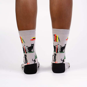 Rear view of model's legs wearing 'Booked For Meow' socks.
