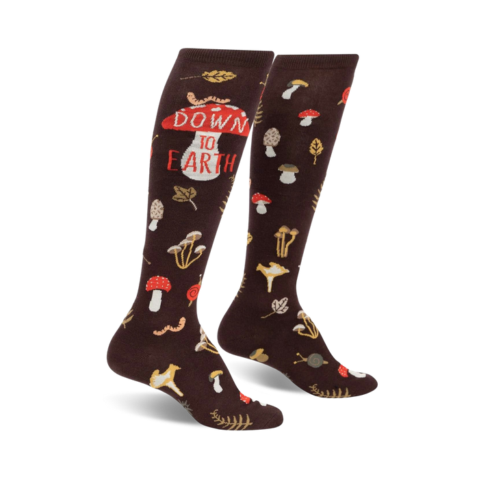 Pair of brown knee-high socks with mushrooms, leaves, worms, and the phrase 'Down to Earth' printed on them.
