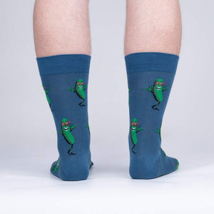 Rear view of model's legs wearing the blue crew socks with dancing pickle design.