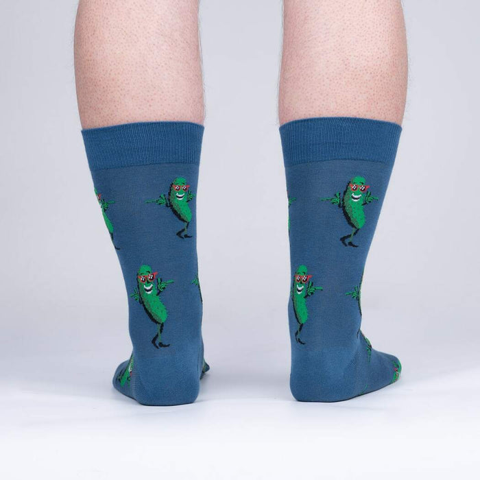 Rear view of model's legs wearing the blue crew socks with dancing pickle design.