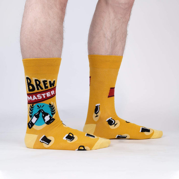 A pair of yellow socks with a beer mug and the words 