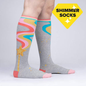 Lifestyle shot of a person wearing the 'It's Magic' knee-high socks, showing the socks' design and fit.