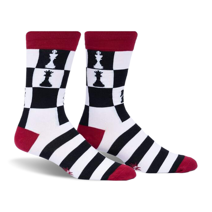 Pair of crew socks in black, white, and red.  Chessboard pattern with chess pieces features on the upper part of the socks and black and white stripes on the lower part.