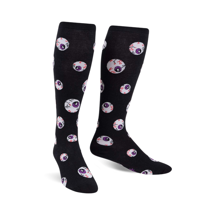 Pair of black knee-high socks with a repeating pattern of purple and red glow-in-the-dark eyeballs.
