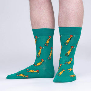 A pair of green socks with a pattern of cartoon chickens wearing party hats and blowing noisemakers.