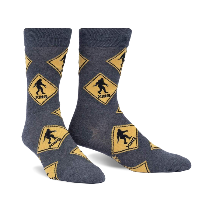 Crew socks in grey with a repeating pattern of yellow diamond-shaped Bigfoot crossing signs. Fun, quirky design.