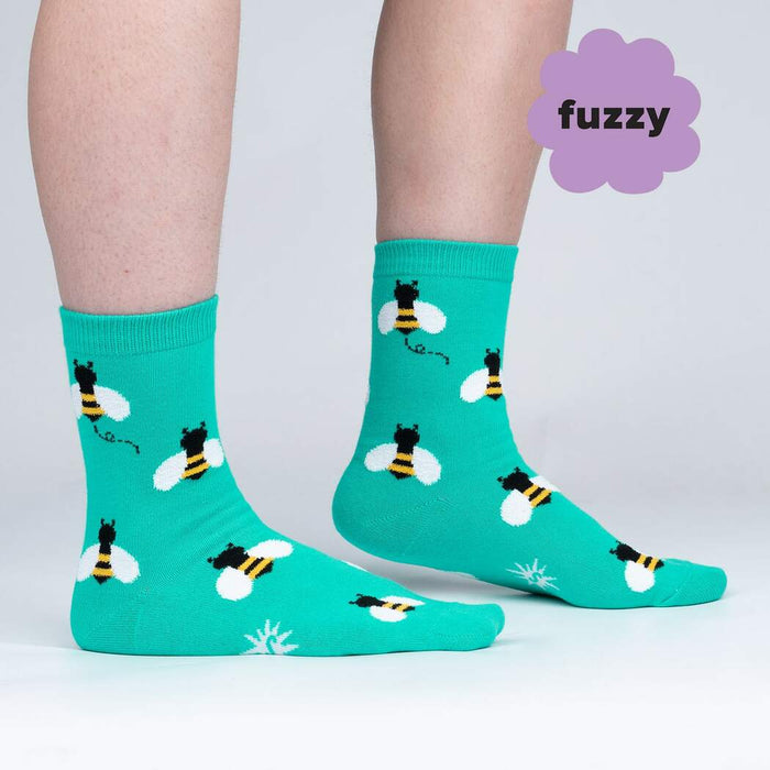 A pair of teal socks with a pattern of cartoon bees.