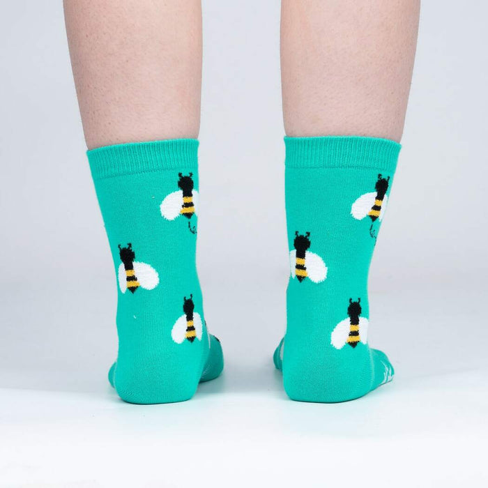 Back view of teal bee socks on a person's legs.