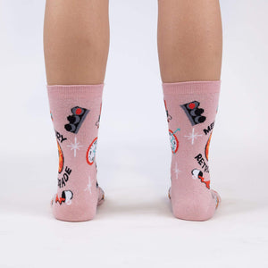 A pair of pink knee-high socks with a pattern of retro rockets, planets, and stars on a light pink background.