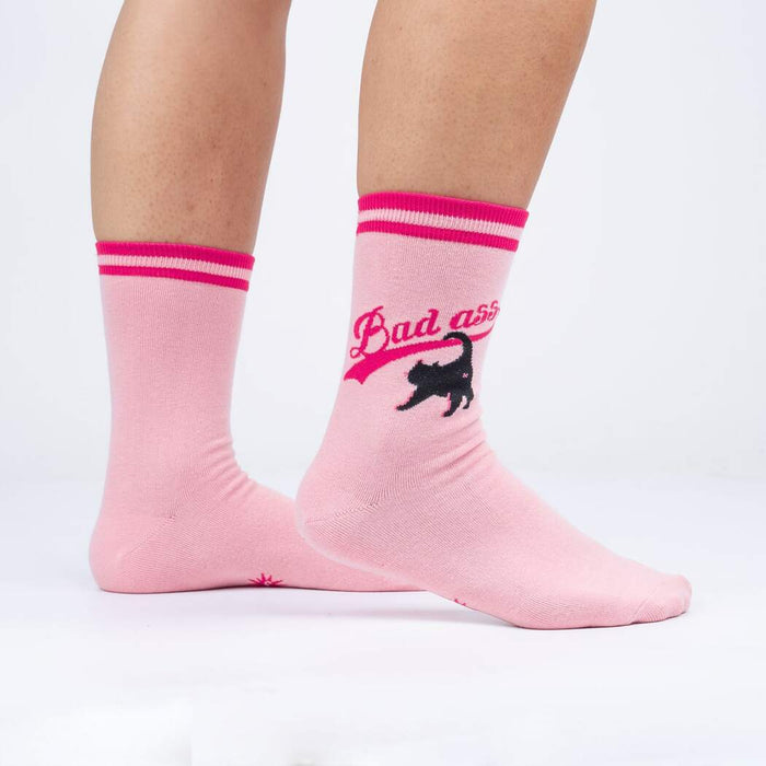 Lifestyle shot of a person wearing a pair of pink 'Bad Ass Cat' crew socks.