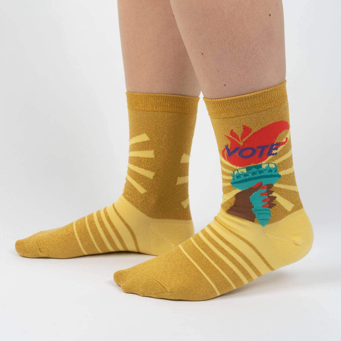 A pair of yellow socks with a colorful pattern of suns and birds on the back.