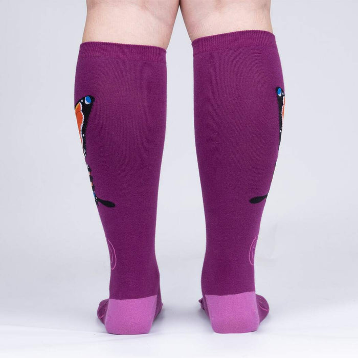 A pair of purple knee-high socks with a butterfly pattern.