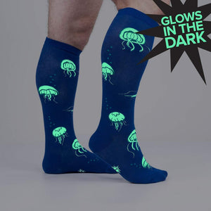 A pair of blue socks with a pattern of glow-in-the-dark jellyfish.