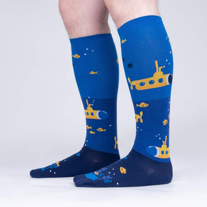 A pair of blue knee-high socks with a pattern of yellow submarines and orange fish.